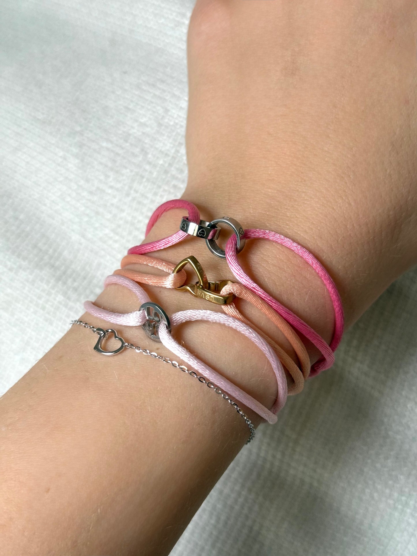 Bracelet sur cordon avec deux anneaux entrelacés en forme de cœur